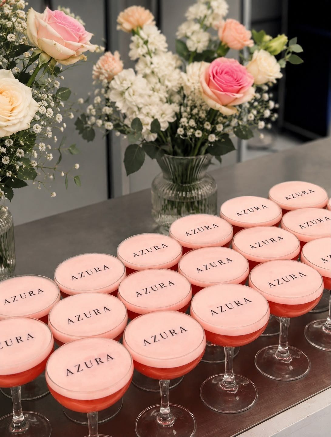 Coupes de cocktail roses marquées Azura, entourées de roses